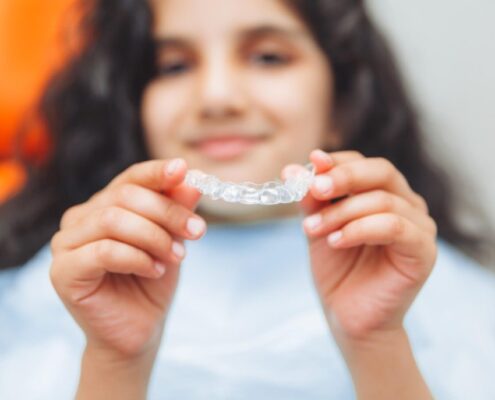 teen girl holding braces dentist puts braces girl dental care orthodontic concept